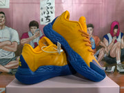 Angled view of the yellow and blue sneakers, showing the side panels and sole
