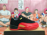 Side profile of a black and red Jordan basketball sneaker showing a gold side detail, textured red overlay, and red outsole.