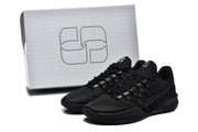 Black shoes beside a white box with a large geometric logo