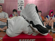 Angled view of a pair of white and black Nike high-top sneakers displaying the zip closure and contrasting panels.