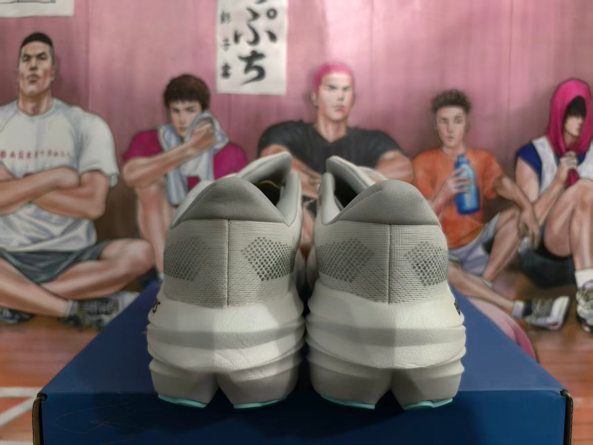 Rear view of a pair of white Brooks running shoes showing patterned heel details and sculpted soles.