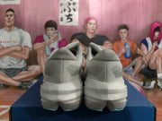 Rear view of a pair of white Brooks running shoes showing patterned heel details and sculpted soles.