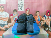 Top-front view of the pair showing black textured tongues, black laces, blue side panels, and blue outsoles.