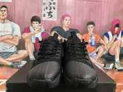 Front view of a pair of black Nike basketball sneakers showing the laces, textured toe panels, and treaded soles.