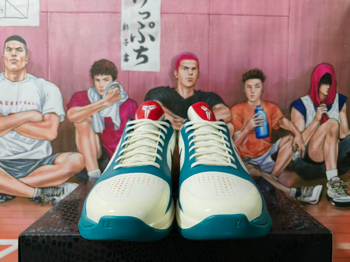 Front view of cream and teal Nike basketball sneakers with red tongue accents, displayed on a patterned box.