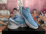 Angled view of blue Nike Kobe basketball shoes showing the textured upper and white midsole