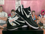 Angled view showing the black textured toe box, white laces, contrasting Swoosh, and layered black-and-white outsole.
