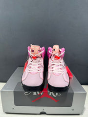 Front view of the pair showing white laces, pale pink toe boxes, and black outsoles.