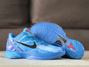 Pair of blue basketball shoes with one shoe tilted to show the translucent outsole and red outsole detail.