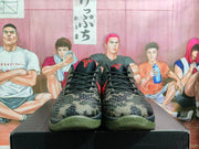 Front view of the paired sneakers showing black laces, textured camouflage toe boxes, red tongue logos, and olive-toned outsoles.