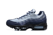 Side view of a Nike Air Max 95 sneaker showing layered navy and light blue panels and visible Air units.