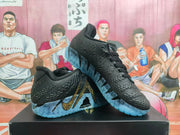 Angled view of the pair showing the black textured uppers, laces, gold swoosh detail, and blue outsoles.