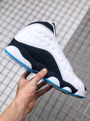 Side view highlighting the white perforated panel, black lower section, and blue outsole trim.