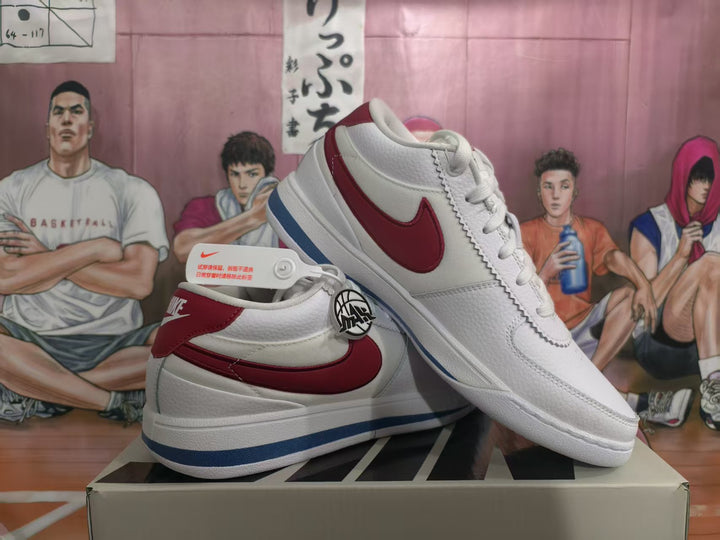 Pair of white low-top Nike sneakers with red side panels and blue outsole detailing displayed on a shoebox.