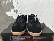Front view of black lace-up Converse trainer-style sneakers with gum-colored outsoles.