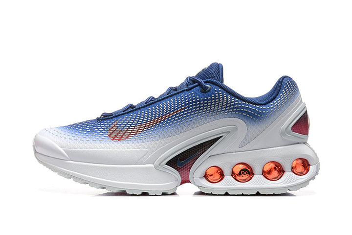 Side view of blue and white Nike Air Max DN sneakers with red-orange cushioning pods.