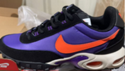 Close-up side view of a purple and orange sneaker with black trim.