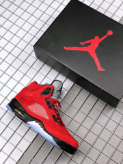 Red and black Jordan sneaker displayed beside a black shoebox with a red Jumpman logo.