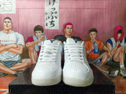 Front view of white lace-up basketball shoes with perforated toe areas.
