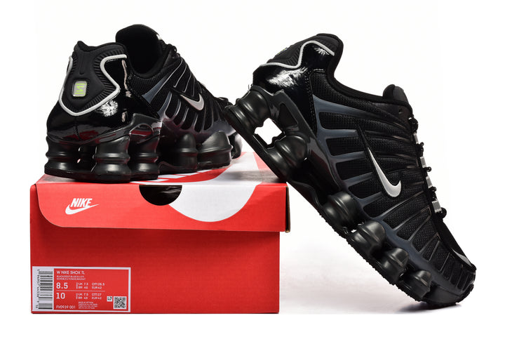 Black Nike Shox TL sneakers with white Swooshes displayed beside a Nike shoe box; the box label shows sample sizes.
