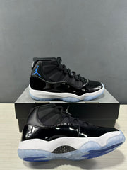 Close angled view showing the glossy black upper, black textile collar and translucent blue outsole.