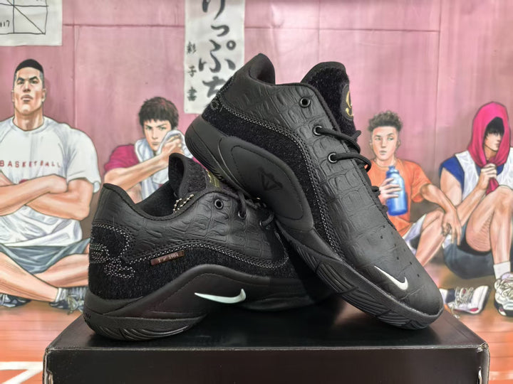 Pair of black low-top basketball shoes with textured overlays and contrasting side logos