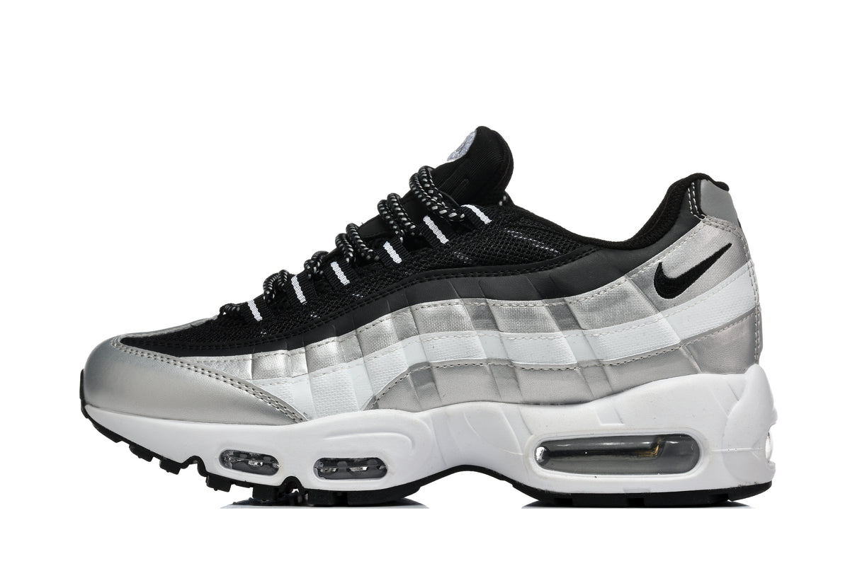 Side view of a black, silver and white Nike low-top sneaker with visible air units in the midsole.
