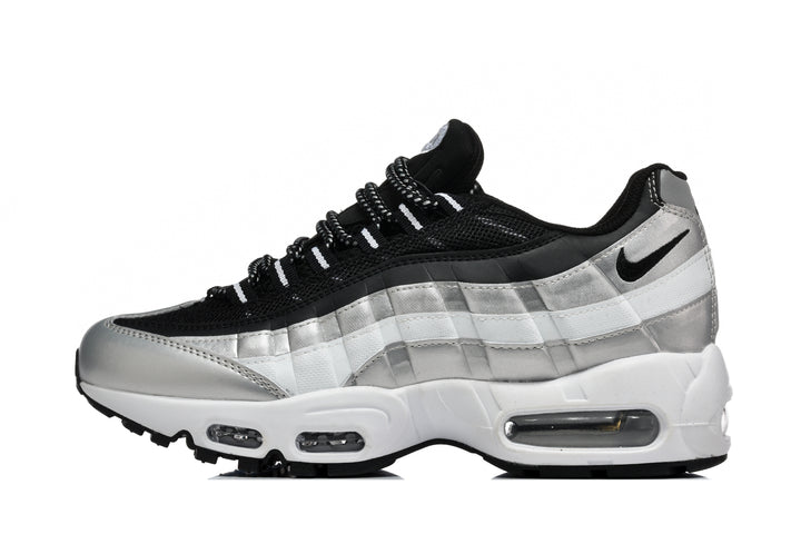 Side view of a black, silver and white Nike low-top sneaker with visible air units in the midsole.