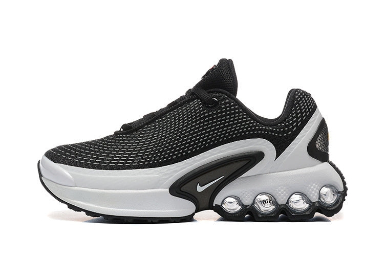 Side view of a black and white Nike-style low-top sneaker with a patterned upper, side Swoosh, and sculpted sole.