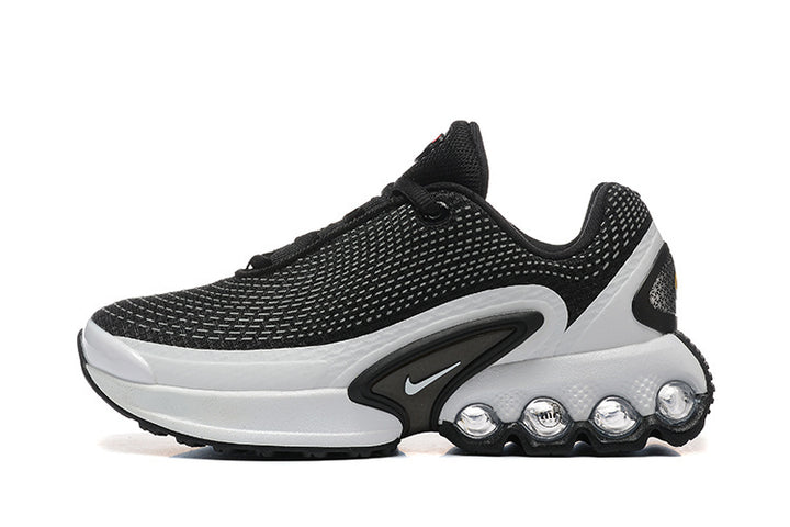 Side view of a black and white Nike-style low-top sneaker with a patterned upper, side Swoosh, and sculpted sole.