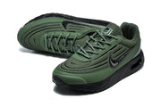 Angled top view of a pair of green and black Nike Air Max VERSA sneakers.