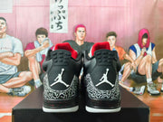 Rear view of black and white Jordan 3-style sneakers with elephant-print overlays, red collar lining, and Jumpman heel logos.