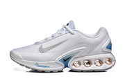 Side view of white Nike Air Max DN sneakers with silver Swoosh details, blue accents and heel cushioning units.