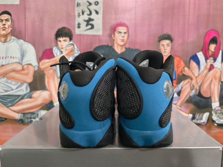 Rear view of black and royal blue Jordan basketball sneakers on a box.