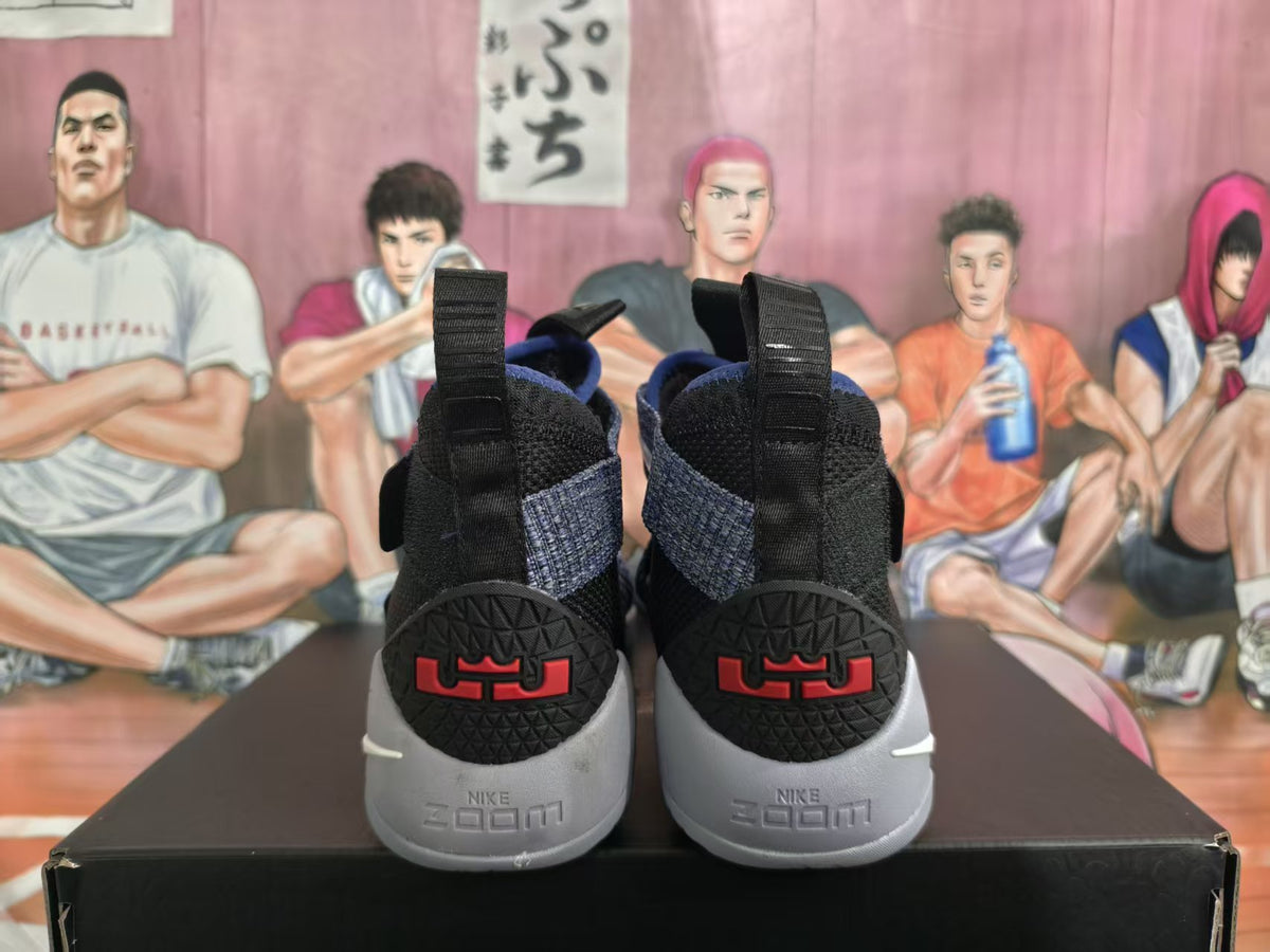 Rear view of black and purple Nike basketball shoes showing heel pull tabs, red heel details, and visible Zoom branding.