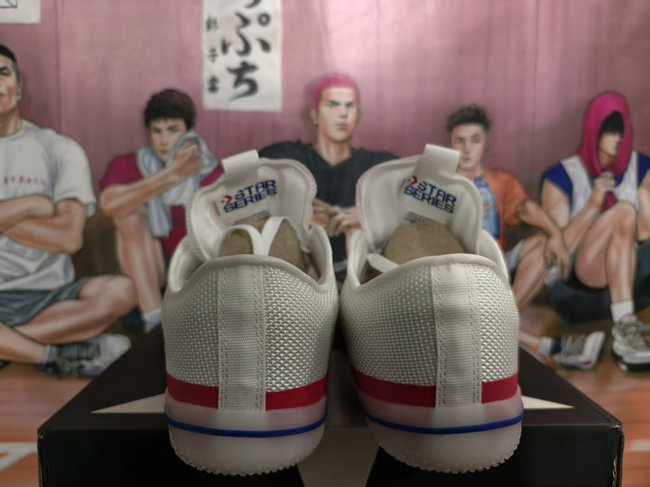 Rear view of white sneakers showing red and blue heel and outsole accents, with All Star Series tongue labels visible.