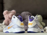 Rear view of the sneaker pair showing white heel panels, purple collars, and gold Nike lettering.