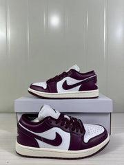 Pair of burgundy and white low-top Jordan sneakers displayed on a shoebox.