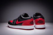 Rear view of black and red low-top sneakers showing heel branding and red heel panels.
