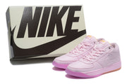Pink sneakers displayed beside a Nike-branded shoe box.