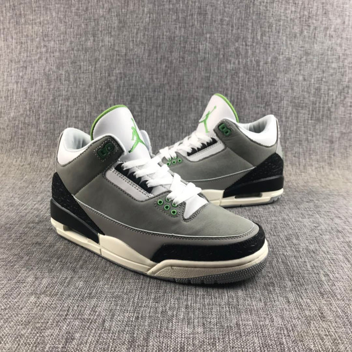 Pair of gray Jordan Air Jordan 3 sneakers shown from a front three-quarter angle with black, white, and green details.