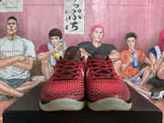 Front view of a pair of red and black Nike basketball sneakers with patterned uppers and red-and-black laces.