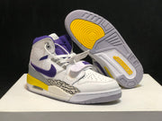 Three-quarter product view showing the pair, grey outsole, yellow traction area, elephant-print side panels, and visible heel air unit.