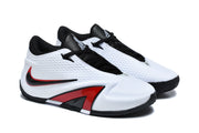 Angled view of white low-top basketball shoes with contrasting black and red details