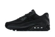 Side profile of a black Nike Air Max 90 sneaker showing the mesh upper and heel Air unit.