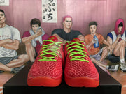 Front view of the red basketball sneakers highlighting the textured toe boxes and bright green laces.