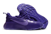 Tonal purple sneakers shown with one shoe lifted to display the outsole.