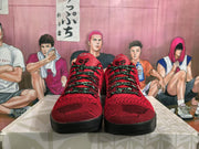 Front view showing the red textured uppers, black patterned laces, dark toe areas, and contrasting tongue logos.