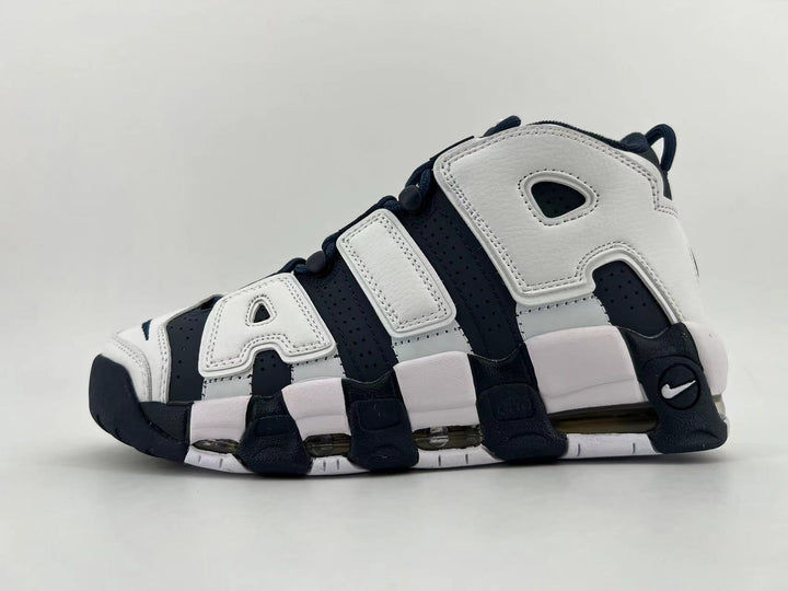 Side view of white and navy Nike Air More Uptempo sneakers with oversized AIR lettering and a visible Air unit.
