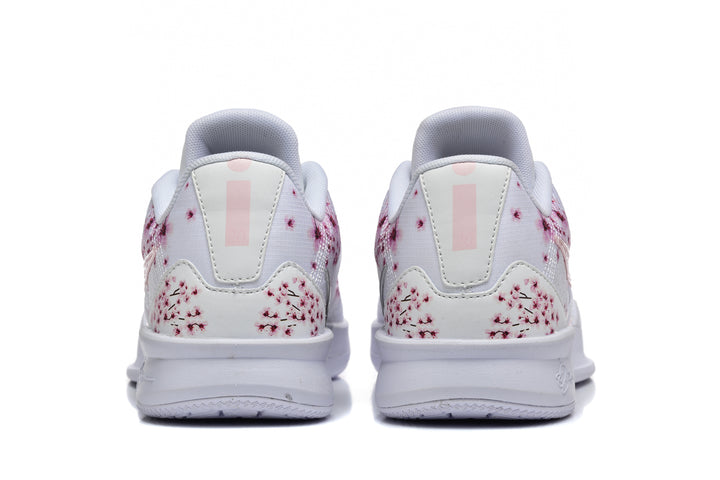 Rear view of white low-top Nike basketball shoes with pink floral graphics on the heels.